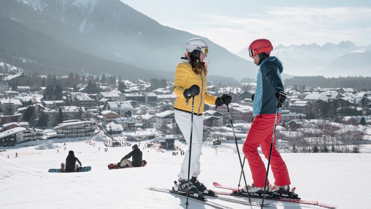 Zwei Menschen beim Skifahren neben Ferienhaus für den Winterurlaub in Reith bei Seefeld